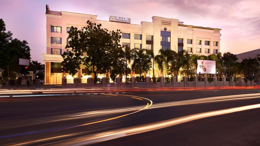 An image of a building covered by trees on the road